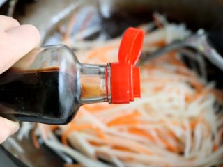 10、素炒萝卜双丝,再加入1小勺生抽调味，翻炒均匀；