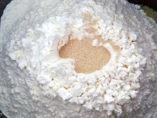 7、适合新手的一次性发酵酸奶小餐包,面粉上面挖一个洞，倒入酵母，用面粉把酵母埋起来