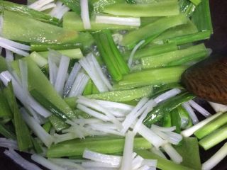 2、家庭版水煮肉片,如图油热后入蔬菜煸炒片刻撒点点盐翻炒均匀装入容器里备用（蔬菜几乎被炒熟变奄）