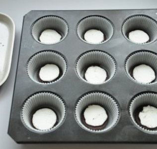 8、奥利奥杯子乳酪蛋糕 ,9连模垫油力士放一片带有夹心的饼干，蛋糕糊入模九分满，将模具在桌面震一下以排除内部大的气泡