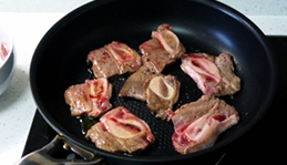 6、黑椒牛仔骨,趁黑椒汁收浓的空档，取不沾煎锅加半匙油，中火烧热后，排入腌好的牛仔骨，煎到一面出血水后，翻面再煎2分钟，牛仔骨7分熟时即可出锅待用。