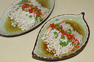 5、剁椒蒸金针菇,将调料汁倒在金针菇上，撒上香葱碎和白芝麻。