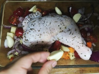 10、法式脆皮烤烤鸡,把腌好的鸡腿放到蔬菜上，再把大蒜随意丢到烤盘里。