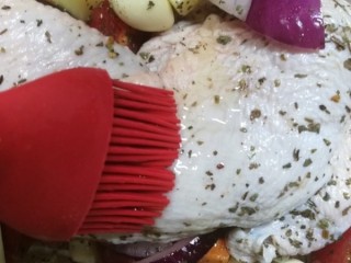 11、法式脆皮烤烤鸡,最后在鸡腿上，刷一层橄榄油。大蒜也可以刷下，再天女散花的撒一波罗勒。