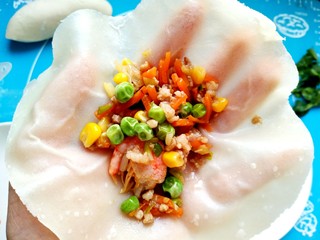 18、年夜饭之五福临门~福袋,取一张饼皮加入馅料用香菜捆绑好。