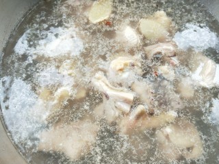 3、美味家常熬炒鸡,锅中放水，放几粒红椒粒，放两片姜烧开，加料酒，放鸡块，汆烫一分钟后，捞出。