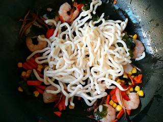 4、海鲜乌冬面（炒）,翻炒均匀至虾仁变成红色，放入乌冬面。