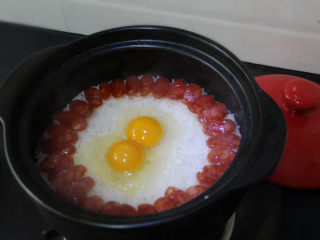 6、广式腊肠煲仔饭,打入两个鸡蛋，盖上盖子继续焖3分钟。