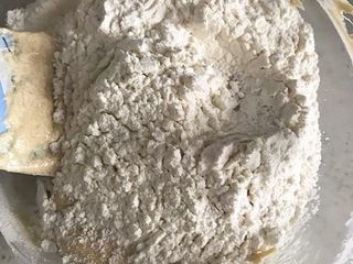 6、金顶蓝莓麦芬,再次筛入三分之一的粉类---------搅拌均匀--------加入剩余的牛奶--------搅拌均匀---------筛入最后三分之一的粉