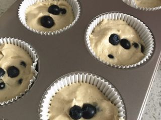 9、金顶蓝莓麦芬, 放纸杯一半的面糊，用勺子将纸杯底部压平，然后挖小洞放入蓝莓