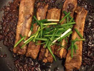 4、姜烧肋排,烧得差不多了放入葱段。肋排里面不太容易熟，所以要多烧一会儿，筷子戳一戳，确定熟透，汤汁收得正好，就可以出锅了。