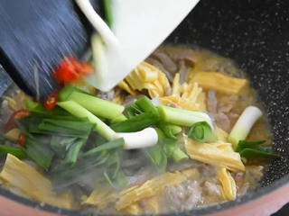 6、又一道下饭利器，营养丰富且简单易学,倒入小米椒和青蒜炒至断生。