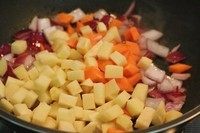 2、椰香咖喱猪排饭,然后把土豆和胡萝卜倒入翻炒一下。