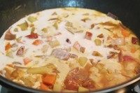 6、椰香咖喱猪排饭,倒入150克的椰浆,混合均匀后再煮一下下至汤汁浓稠即可,不用煮太久。