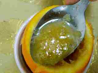 2、香橙鸡蛋羹,先把橙子切成三分之一与三分之二， 然后用勺子把橙子肉挖出来，下面拿个容器接着汁，千万不要浪费哦