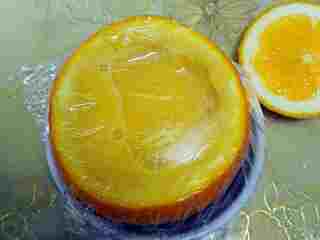 4、香橙鸡蛋羹,将蛋液倒入橙皮内， 刚刚好没有溢出来，包上耐高温保鲜膜