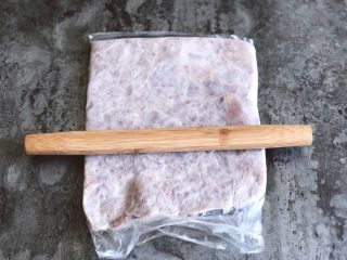 3、芋泥麻薯肉松盒子蛋糕,放在保鲜袋子里,用擀面杖擀压成香芋泥
