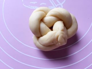 10、牛奶黑芝麻小餐包,两头接紧，盘成圆形，再把接缝处穿过手指环形捏紧即可。