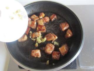 5、糖醋排骨,把葱、姜放进去和排骨翻炒均匀