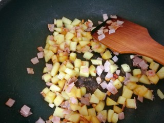 8、培根土豆饭（电饭锅版）,加土豆块翻炒，最后放点酱油和盐。