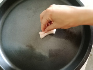 10、霉干菜饼,我用的是插电的平底锅,火开到中档(小档太磨叽,高档太着急,一放上去外皮焦了,里面还没烤酥),锅烧热的时候,切块猪油在上面擦几圈。锅面油乎乎的时候把饼放上去。