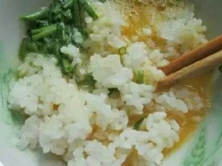 3、鸡蛋煎饭,把米饭和香葱倒入鸡蛋碗里，然后拌一拌