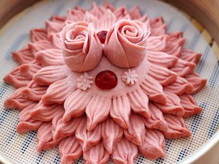 18、花样豆沙馒头,把玫瑰花放在面皮的上面固定好、把红枣切片放在上面点缀一下、我又用了模具刻了几个小花按在面皮上