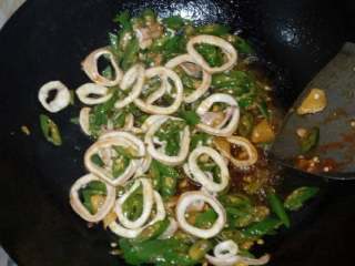 7、辣炒鱿鱼圈,下鱿鱼圈翻炒1分钟左右，辣椒差不多熟了放入调味料翻炒均匀即可出锅