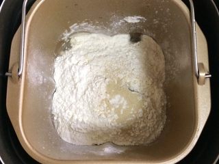 1、红糖小锅盔,在面包机桶内加入温水、面粉和酵母粉,启动和面程序。