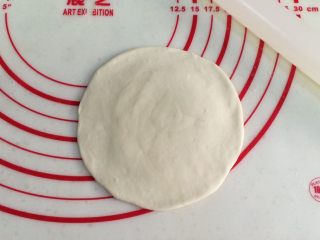 6、红糖小锅盔,取一份面团,用擀面杖擀成中间厚周围薄的圆面皮。