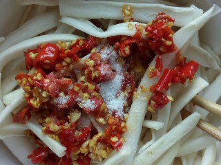 5、辣椒萝卜条,萝卜表皮干燥了，尝一下盐味，这个时候已经是脆的了，盐味不够，再加一点????我就是。同时拌入剁辣椒，少许香芝麻油