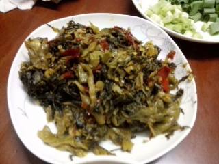 5、家庭自制酸菜鱼,将李记酸菜内的调料包不用，只要酸菜，还是热锅放一大勺油烧至八成热，倒入酸菜炒到酸菜将油吸干即可，装盘备用。