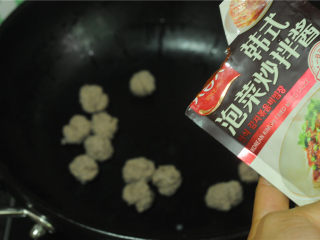 9、牛肉丸烫上海青,另起油锅，转小火，将汆烫好的牛肉丸倒进去，加入韩式泡菜炒拌酱