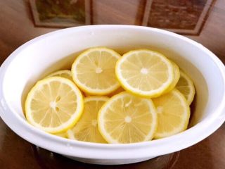 2、柠檬枇杷膏,柠檬表面用盐揉搓，冲洗干净，切片去籽，铺在炖锅内胆底层