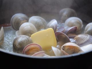 9、酒蒸文蛤,有文蛤微张口放入黄油，快速翻拌一下。