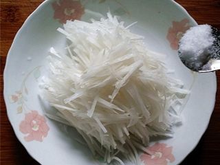 4、响油萝卜丝,放入盘中加1勺食盐拌匀