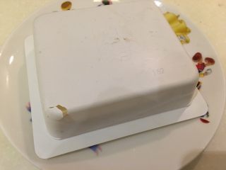 2、想要你-山药豆腐,撕开豆腐包装,取一平碟倒扣豆腐,并在盒子底部开小口,让豆腐自己滑出盒子