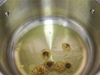 8、菊花雪梨酱,将菊花清洗，留2朵备用，其他放入锅中，加水煮，待菊花味道完全出来后，关火。捞去残渣。