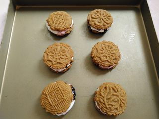 14、棉花糖淋酱饼干,趁热把另外一块饼干花纹朝上，盖在淋了巧克力酱的另一半饼干上