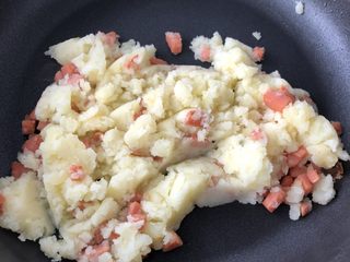 2、火腿香葱土豆泥,火腿切丁，起火，倒入少量食用油，油不要多，不然最后会很腻，放入火腿小火炒一分钟后倒入土豆泥，最后倒入葱丁，加入盐后盛出。
