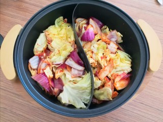 7、冬日佳节暖心韩式部队火锅(附详细蔬菜刻花处理步骤),把炒好的圆白菜和葱头放入火锅里。