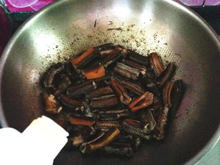 8、蒜苗烧黄鳝,煸至卷起变色后滴入料酒