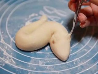 10、新年喜庆花样馒头,用小剪刀在龙头处剪出两个大一些的犄角，在犄角中间再剪一刀。