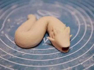 11、新年喜庆花样馒头,用剪刀在犄角四周剪出四个小角，同时嘴部也用剪刀剪开并且塞上红豆作为支撑。