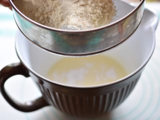 7、奶酪芝麻戚风,再次筛入过筛过的粉类，用手动打蛋器混合均匀至无粉末残留