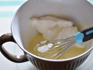 9、奶酪芝麻戚风,取一部分蛋白霜加入蛋黄糊，翻拌均匀，再加入一部分蛋白霜继续用刮刀翻拌