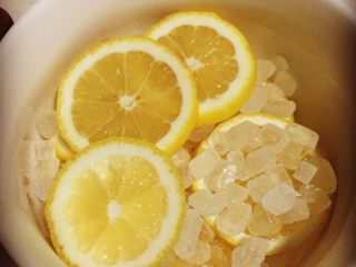 4、柠檬膏,冰糖的话 用黄冰糖最好 但春节放假 很多地方没有开门 超市没有卖黄冰糖的 所以这次使用白冰糖代替 把柠檬切片 铺在碗底一层 然后放一层冰糖 不要加水不要加水不要加水 重要的事情说三遍…