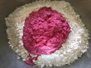 3、蒂凡尼的早餐,将酵母和食盐分别放在面粉的两个不同角落,然后分次加入刚才准备好的甜菜根牛奶混合液,边加边搅拌,将面粉柔和为面团;