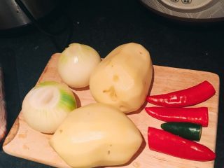 2、快手系列之---大盘鸡,洋葱包去外皮（我这里选用的是白洋葱，用紫洋葱味道会更浓郁一些），土豆削皮，准备好红绿辣椒。