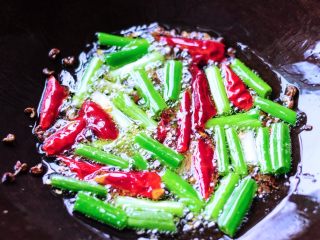 6、凉拌鱼香茄子,炒锅里倒入油放入小葱段、干辣椒段、花椒粒大火爆香成香辣油。